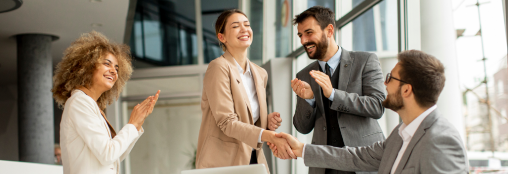 Varias personas sonrientes trabajando juntas en la oficina, representando el agradecimiento por el apoyo recibido